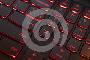 Colorful keyboard for gaming. Backlit keyboard with red color scheme. Colorful light keyboard