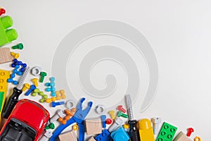 Colorful kids toys border. Toy tools, construction blocks, cubes on white background as frame. Flat lay. Top view.