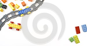 Colorful kids toys flat lay with toy train, railway, plastic and wooden blocks on white background.