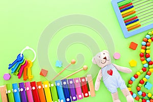 Colorful kids toys on green background. Top view, copy space
