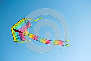 Colorful kite drifting in blue sky