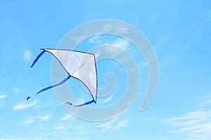 Colorful kite flying in the blue sky through the clouds