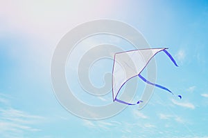 Colorful kite flying in the blue sky through the clouds