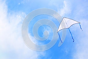 Colorful kite flying in the blue sky through the clouds