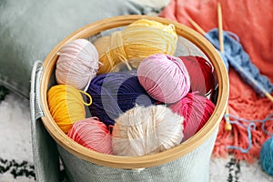 Colorful knitting yarn in basket on floor