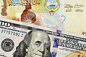 A colorful Kuwaiti quarter dinar with an American one hundred dollar bill close up