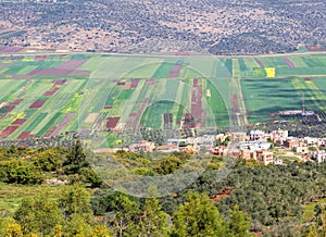 Colorful landscape view on agricultural Netufa valley and Arab settlement.Plowed land, colorful fields, olive tree plantations