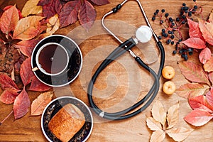 Colorful leaves on wooden background medical stethoscope