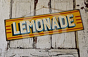 Colorful lemonade sign hangs from an old white door