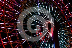 Colorful light fluorescent on structure of ferris wheel with dark night background