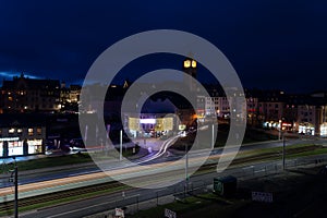 Colorful light stripes of cars on the street at night in front of a church in the city of plauen