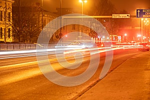 Colorful light traces from busy night traffic on the Umea city street, foggy autumn weather, Sweden