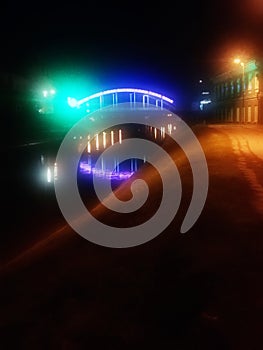 The colorful lights on the bridge with river under the bridge.