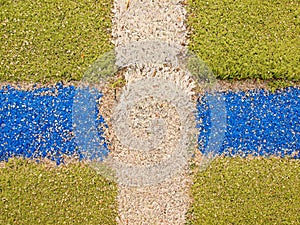 Colorful lines in empty outdoor handball playground, plastic light green surface on ground and white, red and blue bounds lines.