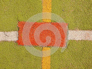 Colorful lines in empty outdoor handball playground, plastic light green surface on ground and white, red and blue bounds lines.