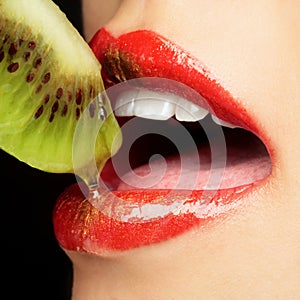 Colorful lips eating kiwi