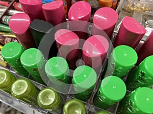 Colorful lipstick bottles on shelves in cosmetic store for sale