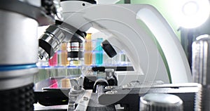 Colorful liquid laboratory test tubes and a row of microscopes