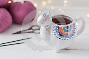 Colorful Llama shaped tea or coffee mug with knitting needles, scissors and wool yarn