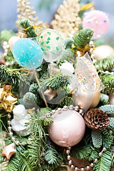 Many colorful lollipop on decorated Christmas tree, top view,balls, stars, cones, hearts, gold toys