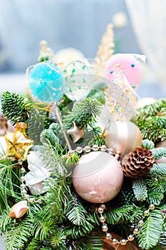 Many colorful lollipop on decorated Christmas tree, top view,balls, stars, cones, hearts, gold toys