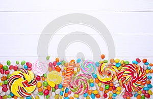 Colorful lollipops and different colored round candy on white background