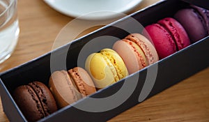 Colorful macarons in a black box, close up view