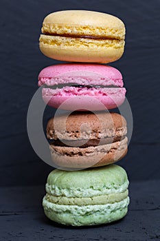 Colorful macarons on a black wood