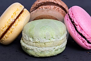 Colorful macarons on a black wood