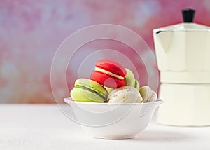 Colorful macarons cookies in white bowl on pastel background, copy space