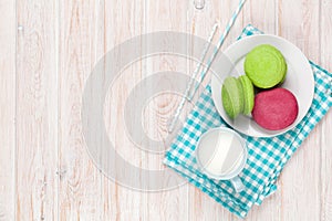 Colorful macarons and cup of milk