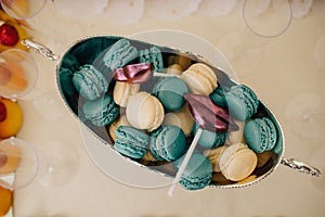 Colorful macarons on pyramid-shaped plastic tower stand as part of candy bar sweet table