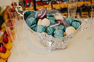 Colorful macarons on pyramid-shaped plastic tower stand as part of candy bar sweet table