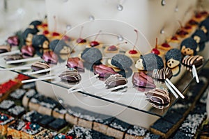 Colorful macarons on pyramid-shaped plastic tower stand as part of candy bar sweet table