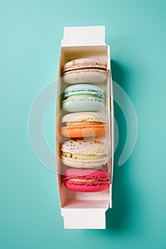 Colorful macarons. Small French cakes. Sweet and colorful french macarons in a box on a blue background. Gift for Valentine`s Day