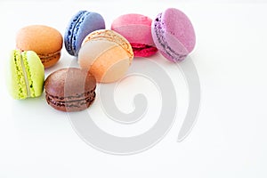 Colorful macarons on white background, close up view