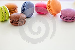 Colorful macarons on white background, close up view