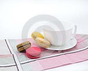 Colorful macarons with white cup and plate