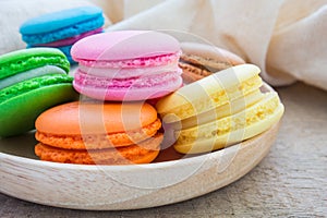 Colorful macarons on wooden plate