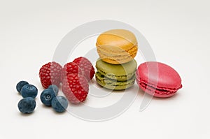 Colorful macaroon coolies with raspberry and blueberry berries