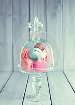 Colorful macaroons in a glass vase photo