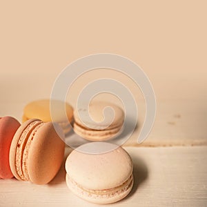 Colorful macaroons on white wooden background