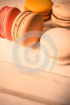 Colorful macaroons on white wooden background