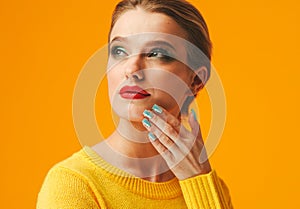 Colorful makeup woman red lips in yellow clothes on color happy summer fashion background manicured nails