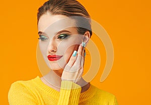 Colorful makeup woman red lips in yellow clothes on color happy summer fashion background manicured nails