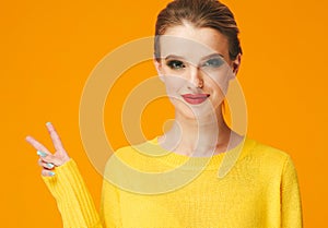 Colorful makeup woman red lips in yellow clothes on color happy summer fashion background manicured nails