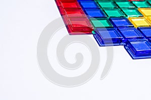 Colorful matching blocks like tetris on white background, high contrast colours, red blue yellow and green transparent tiles