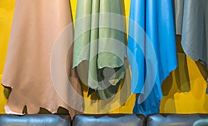 Colorful material of genuine leather brown, green, blue and gray textured for variety leather product on the yellow wall