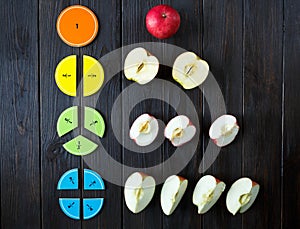 Colorful math fractions and apples as a sample on brown wooden background or table. interesting math for kids. Education photo
