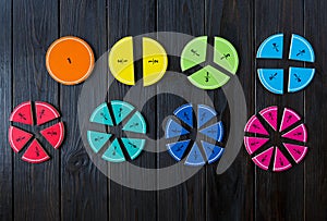Colorful math fractions on brown wooden background or table. interesting math for kids. Education, back to school concept.